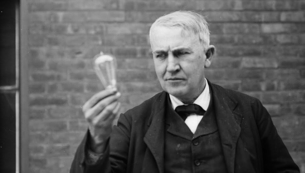 Thomas Edison holding a light bulb